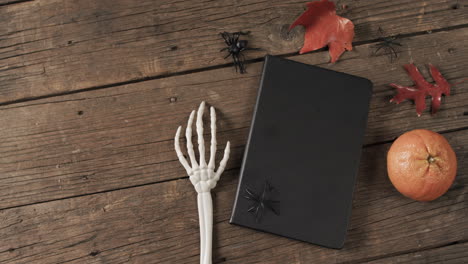 video de manos de esqueleto de halloween, cuaderno y decoraciones con espacio de copia en fondo de madera