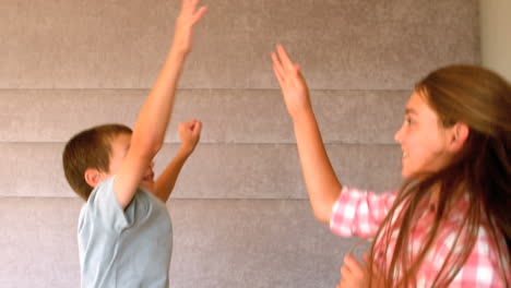 Siblings-high-fiving-in-bedroom