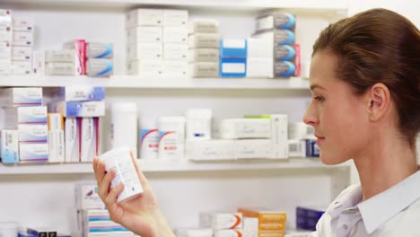 farmacéutico comprobando el medicamento en el estante