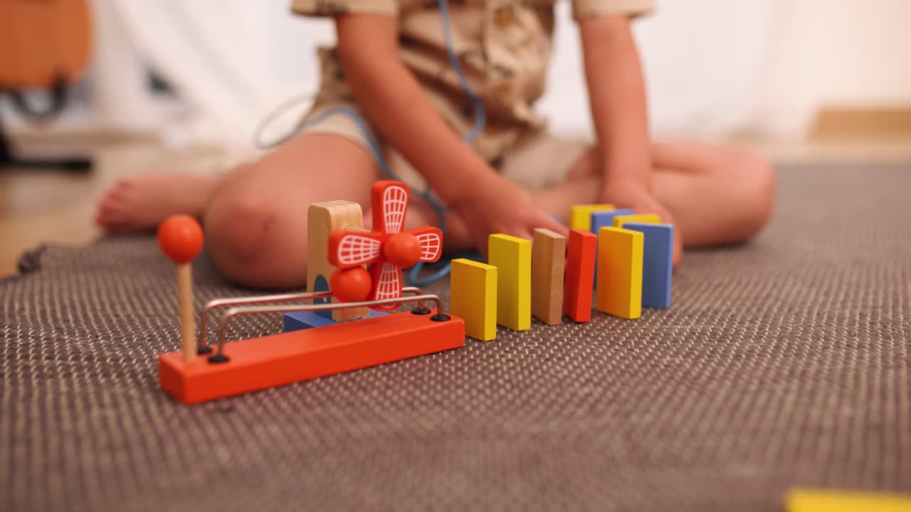 Child playing with dominoes and wooden toy