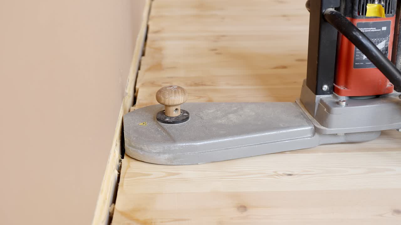 Process of sanding a wooden floor edge during a home renovation project