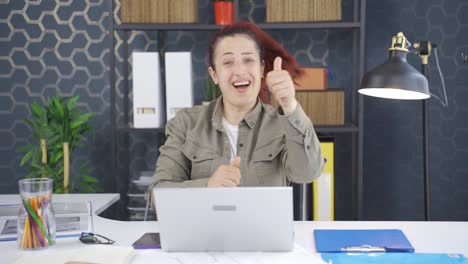 mujer de negocios aplaudiendo mientras mira a la cámara con orgullo y alegría.