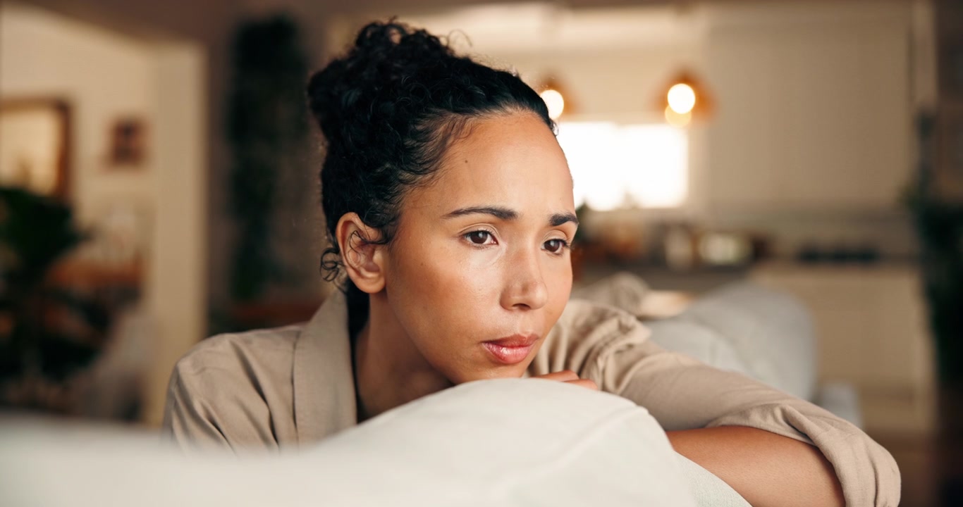 Pensive Young Woman Resting Her Chin on Her Hands at Home