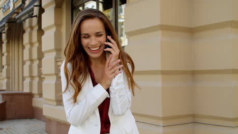 happy business woman talking mobile phone outdoors. cheerful businesswoman