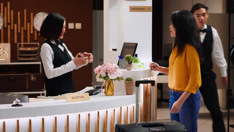 asian hotel staff checking passport for id at check in