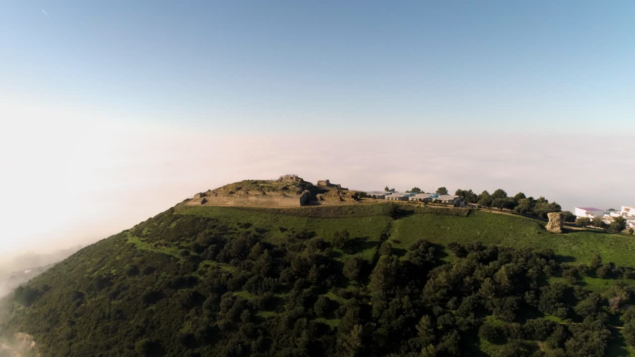 Aerial rotating drone shot over the mountains of medina sidonia in andalucia spain under blue sky during a sunny day overlooking the landscape