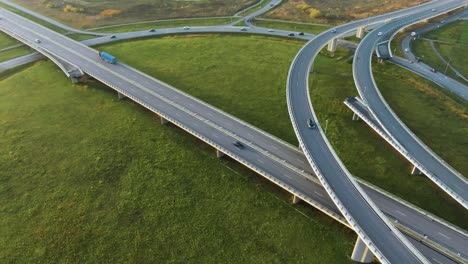 an aerial view of a country highway with bridges on which cars drive in the sunny evening