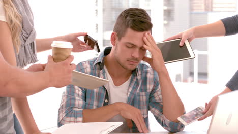 Stressed-businessman-surrounded-by-work-colleagues