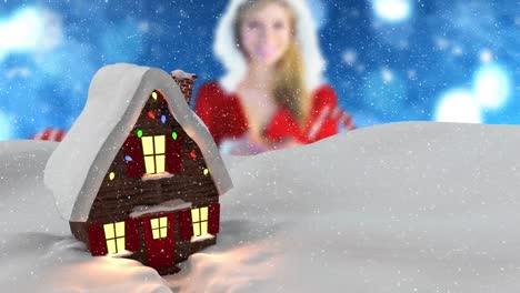 Animation-Von-Schnee,-Der-über-Eine-Winterlandschaft-Mit-Haus-Und-Kaukasischer-Frau-Im-Weihnachtsmannkostüm-Fällt