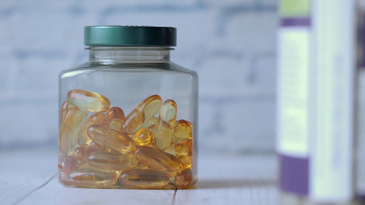 Glass Bottle Filled With Golden Omega 3 Fish Oil Capsules