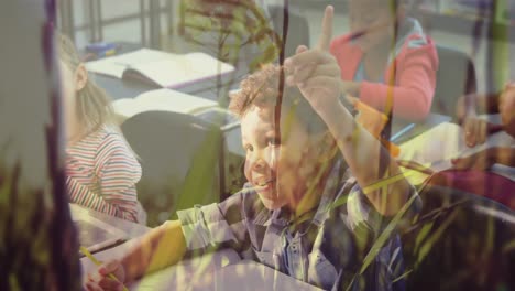 Boy-raising-his-hand-in-the-class-at-school-against-grass-moving-in-the-wind