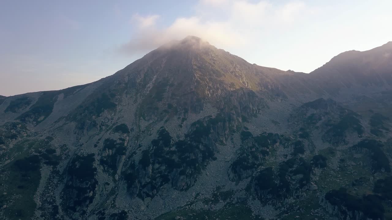 volando hacia la cima de una majestuosa montaña con nubes en la cima