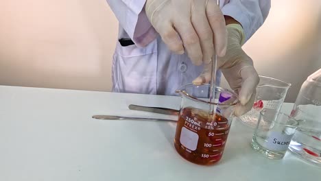 scientist conducts a color-changing chemical experiment using potassium permanganate in a lab setting with controlled lighting