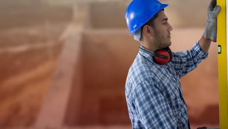 Animation-of-caucasian-worker-in-blue-hard-hat-with-spirit-level-at-construction-site