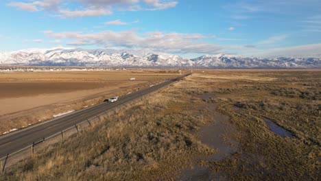 flying-towards-distant-road-in-Syracuse-Utah-using-Rocky-Mountains-as-background
