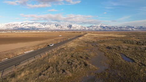 volando hacia una carretera lejana en syracuse utah usando montañas rocosas como fondo