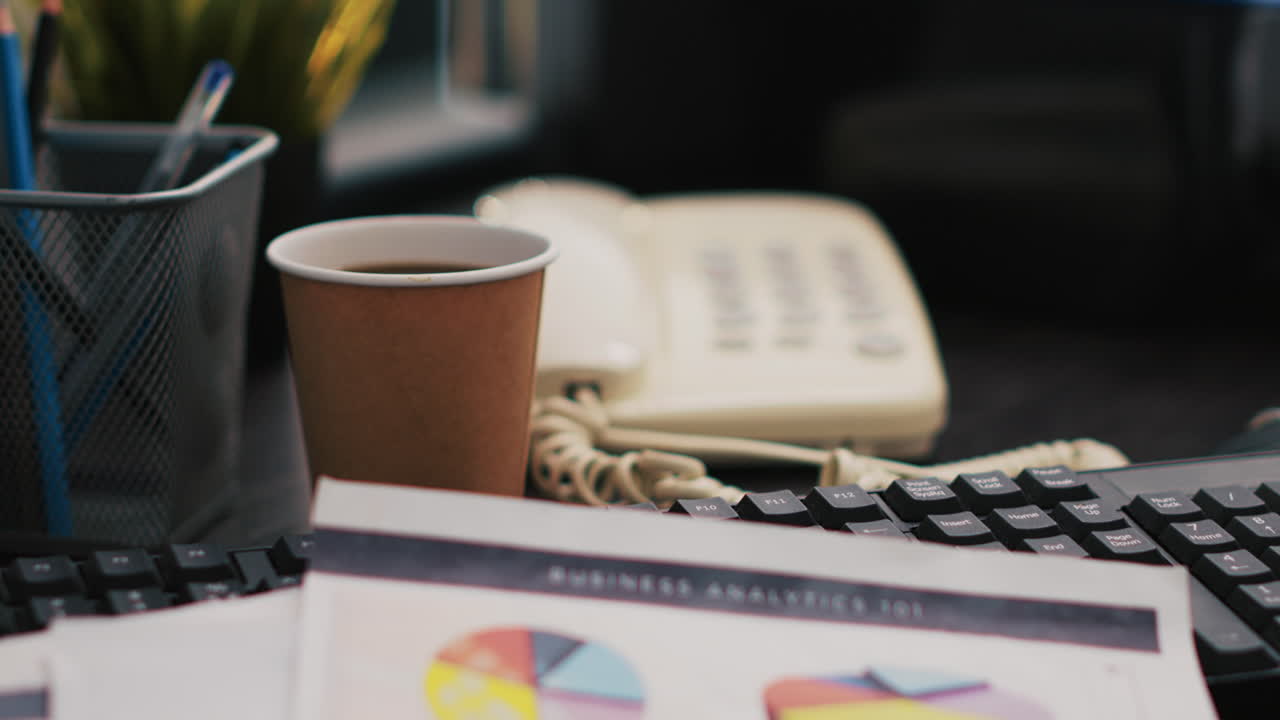Bookkeeping documents containing business analytics next to coffee cup, close up