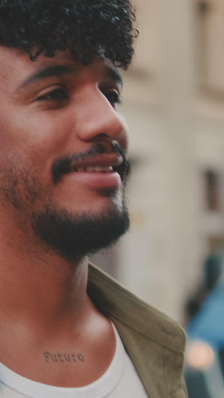 Detailní záběr usmívajícího se muže s vousy a tetováním