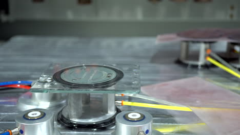 small wet glass panel on an air sucker piston which is holding it still on cnc machine