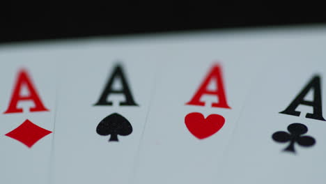 macro detail shot of top of playing cards with all four aces hearths diamonds space cross lying on an elephant while moving as the cards slowly expose from the side