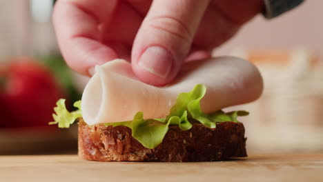 making a ham and lettuce sandwich
