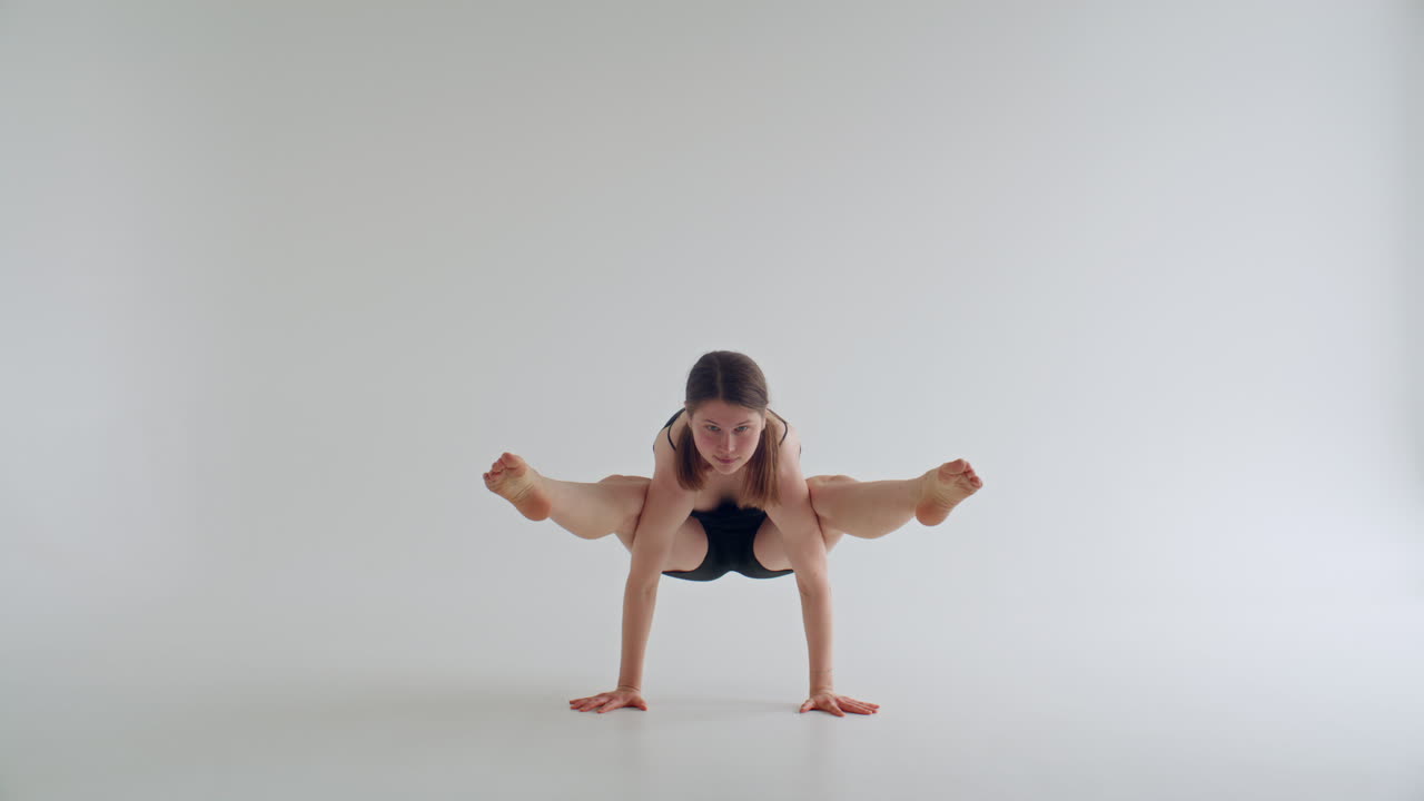 Girl Balancing in Firefly Pose during Hatha Yoga Practice
