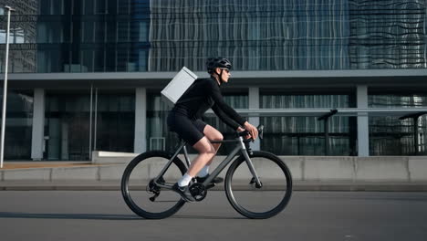 cyclist with delivery box in modern city