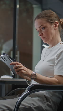 female stock exchange trader monitoring real-time stocks, exchange market charts on digital tablet and computer with multi-monitor desktop. investment agent working in office at night. vertical shot.