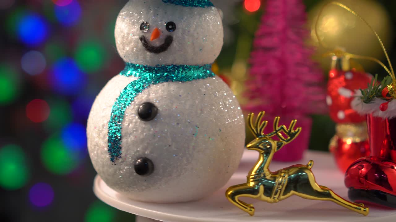 decoraciones de navidad ornamento girando en el árbol y borrosas luces bokeh fondo, hombre de nieve, renos, santa claus, ángeles, calcetín rojo de navidad y bola dorada.