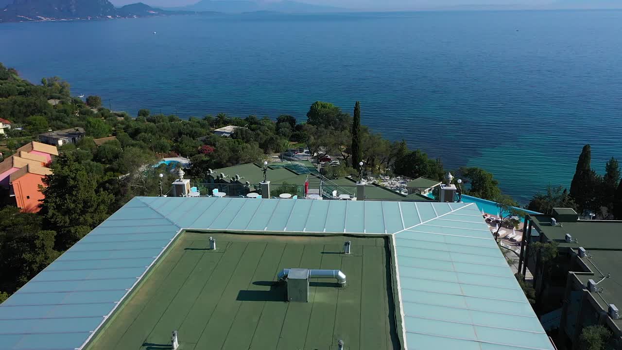 Tracking shot view Hotel Mythos Palace, Corfu, Greece on the sea and the coastline.