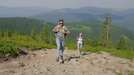 Un-Hombre-Y-Una-Mujer-Con-Mochilas-Corren-Rápidamente-Por-El-Sendero-De-La-Montaña-Cargas-Extremas-Y-Resistencia-4k-Vid