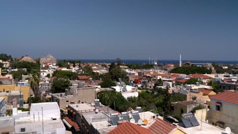 rodas, grecia: toma aérea de drone de odos sócrates (calle de sócrates) con la mezquita de suleiman, que muestra arquitectura medieval cerca del mar mediterráneo. el panel solar está instalado en el techo de las casas