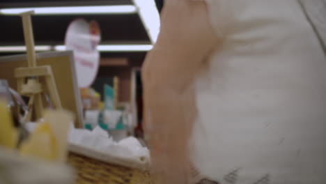 una chica atractiva cliente está comprando pan en el departamento de panadería es la tienda olerlo sonriendo y poniendo en el carrito de compras. estilo de vida saludable y concepto de supermercado.