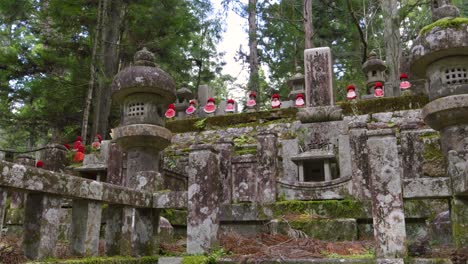 tiro cinematográfico sobre pilares de piedra con estatuas de jizo con sombreros rojos