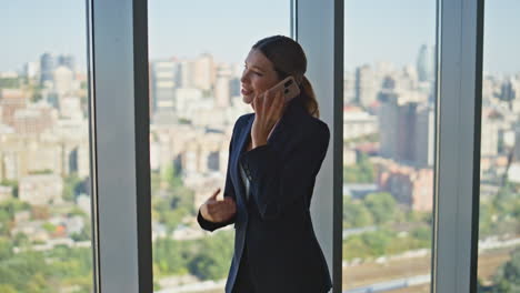young businesswoman speaking cellphone in modern office. smiling worker resting
