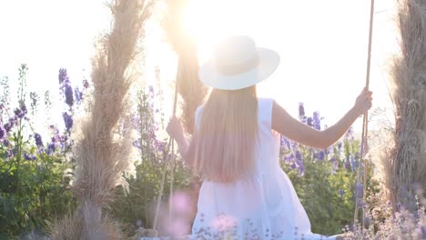 a young lady in a white style is swinging on a beautiful swing in the middle of a field a young lady in a white style is swinging on a beautiful swing in the middle of a field delight in beauty photo session in lavender