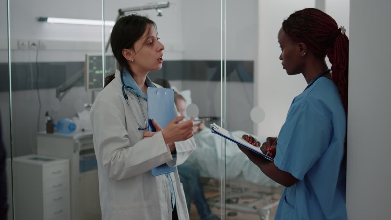 Pediatrician doctor discussing sickness symptom with african american nurse examining diagnosis