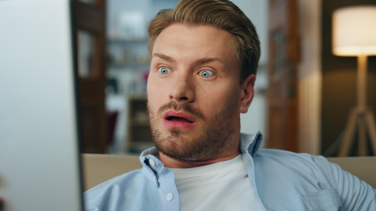 Wondering man surprised face reading tablet closeup. Guy watching tab computer