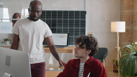 multiethnic men discussing alternative energy project on computer