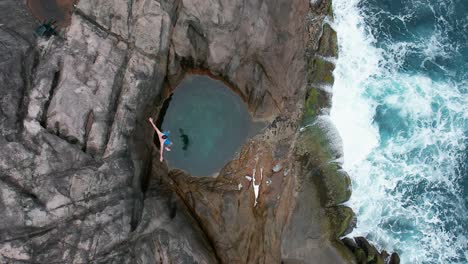 a man jumps into a rock pool