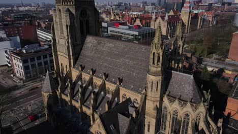 aerial drone flight around the church of the holy name of jesus christ on oxford road in manchester showing the rooftops and its gothic architecture