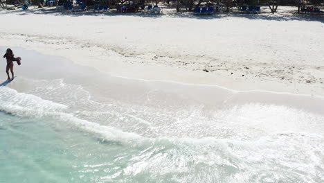 Mujer-Turista-Se-Pone-Gafas-De-Sol-Mientras-Está-En-La-Playa-Tropical---Deslizamiento-De-Drones-A-La-Derecha