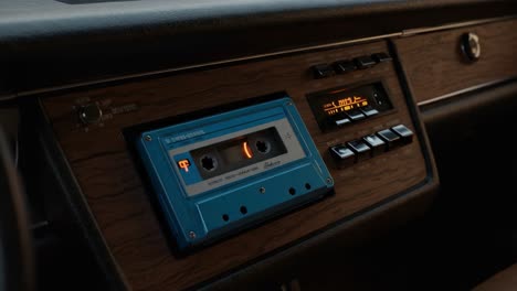 nostalgic auto audio: a close look at a vintage cassette player featuring a classic blue cassette tape in a retro car interior setting