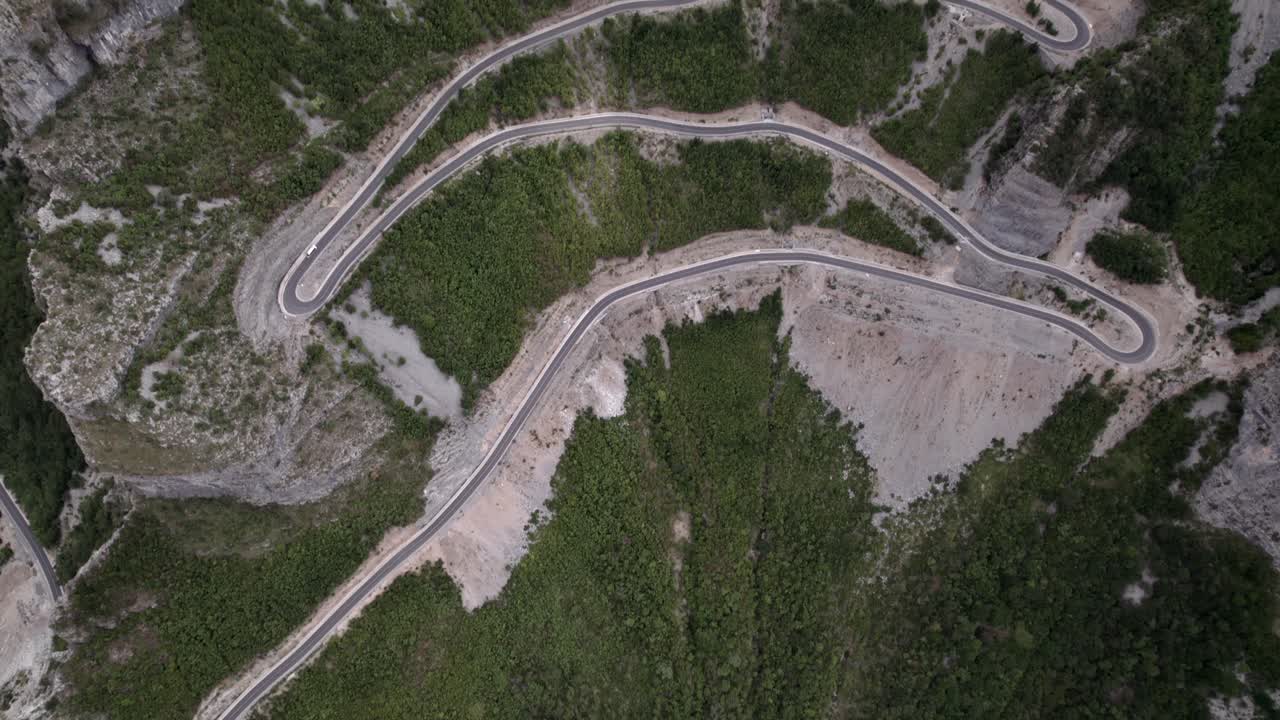 video de drones del anterior avión revelador desde una vista de pájaro sobre el paso de montaña "rrapsh serpentine" en la carretera sh20 en grabom, albania, leqet y hotit se pueden ver vehículos circulando