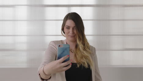 Retrato-De-Una-Joven-Y-Elegante-Mujer-De-Negocios-Rubia-Posando-Tomando-Una-Foto-Selfie-Usando-La-Tecnología-De-La-Cámara-Del-Teléfono-Inteligente