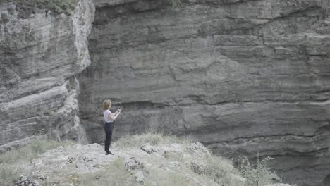 woman taking a video on a clifftop