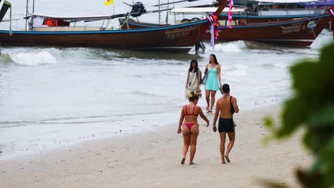 people walking on beach near boats