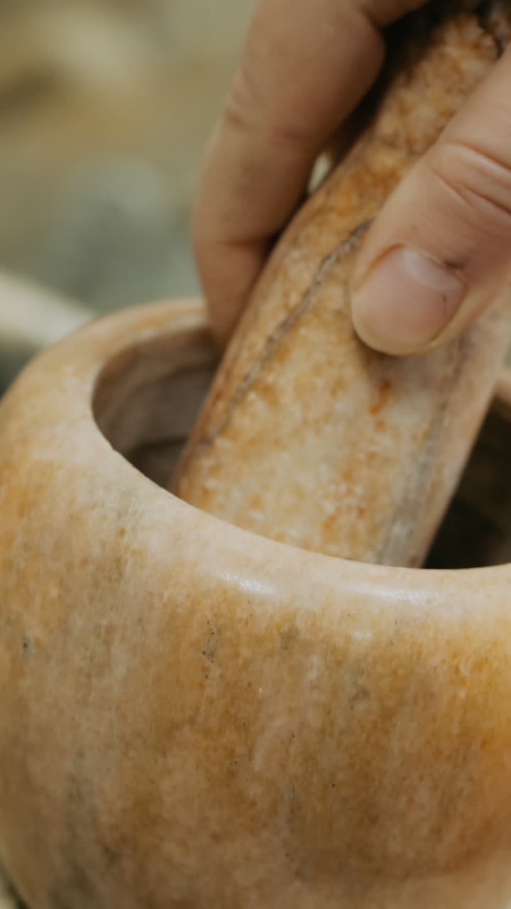Hand Using Mortar and Pestle to Grind Spices