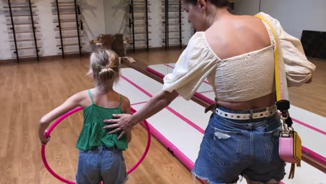 una chica practicando el hooping en un gimnasio.