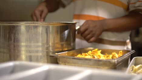 pasta being scooped into a heat tray in slow motion